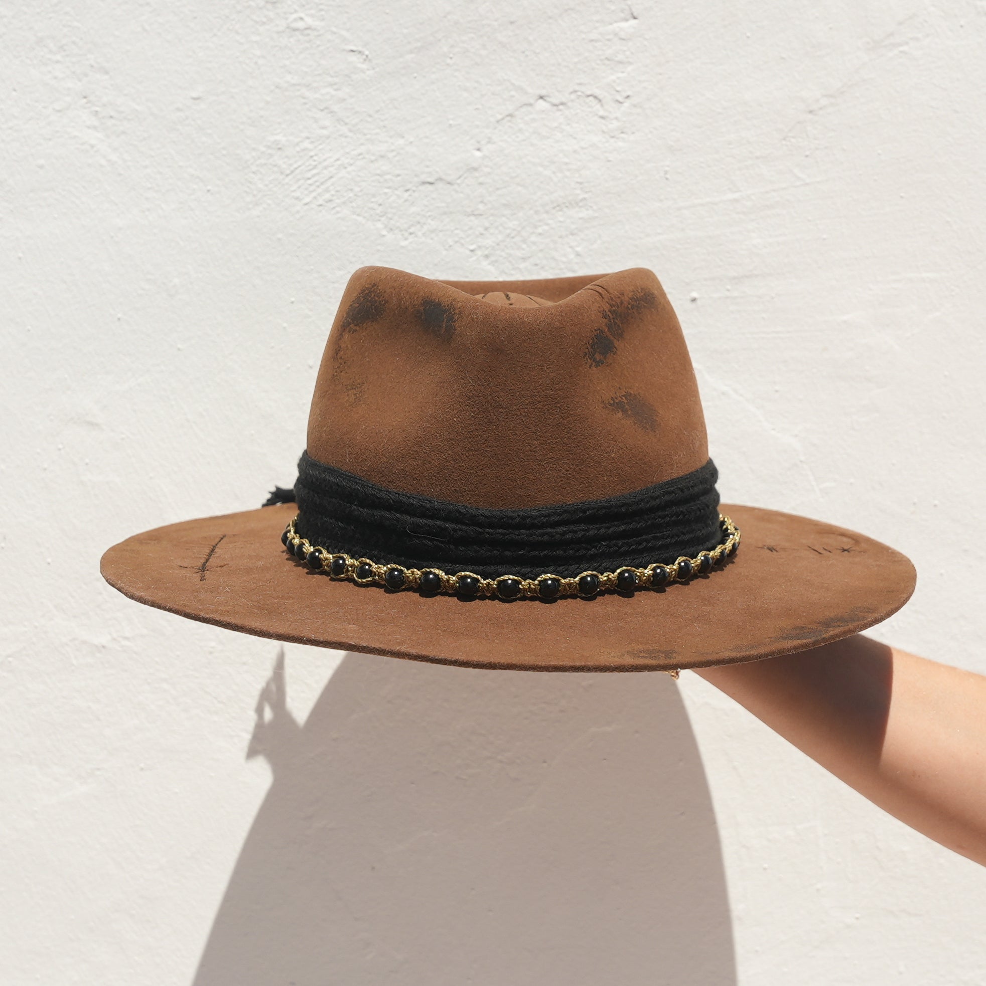 Close-up of Obsidian beaded gold rope on handcrafted Merino wool felt hat — Satori Collection